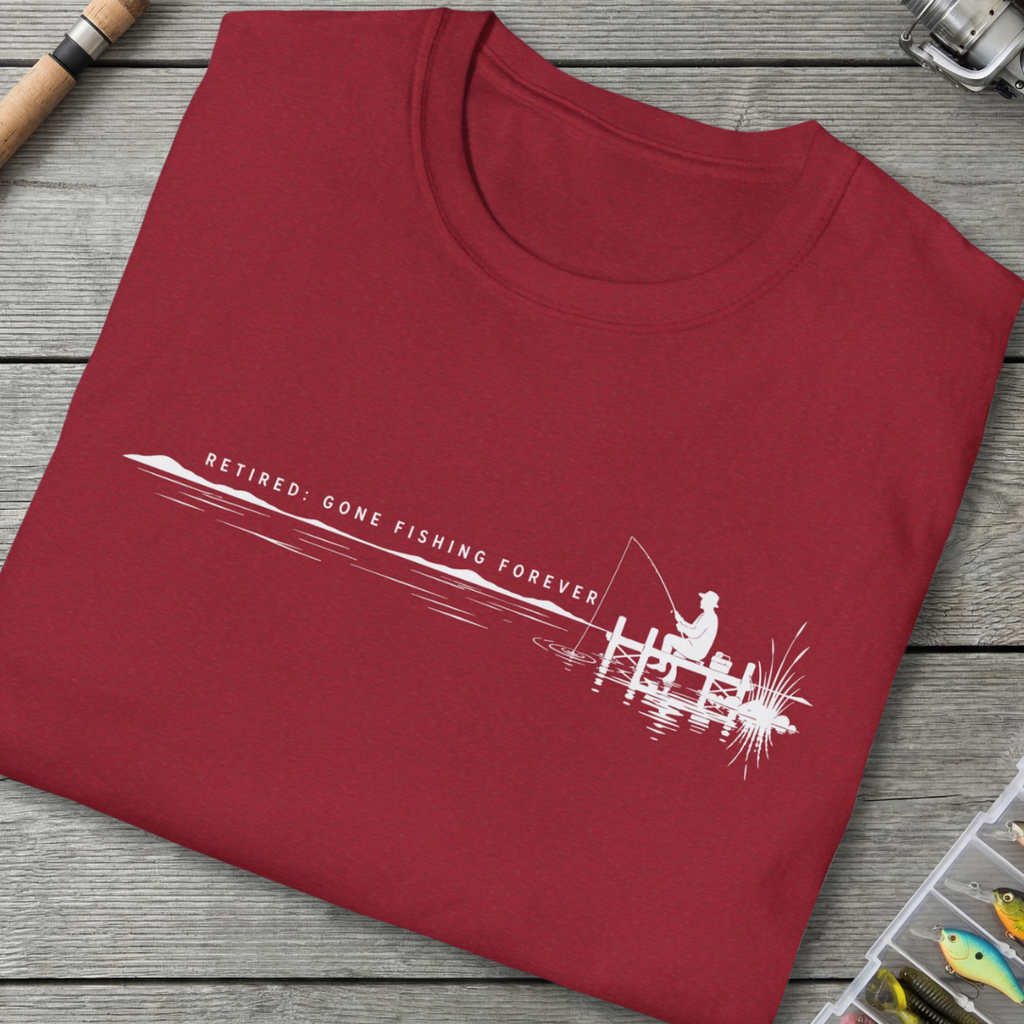 Folded red t-shirt with fishing-themed design on a wooden surface