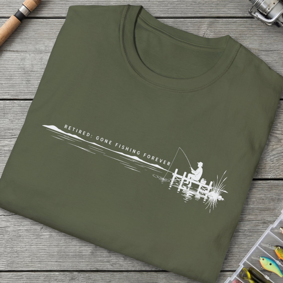 Green t-shirt with fishing graphic and text on a wooden surface
